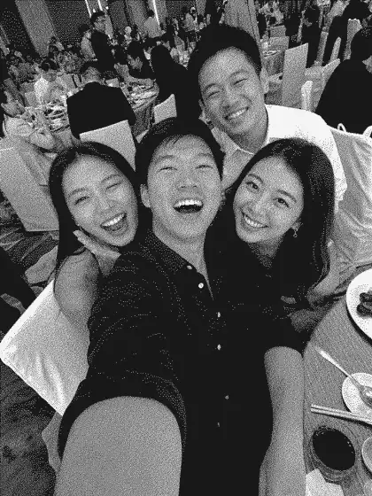 Event guests smiling together in a monochrome group photo