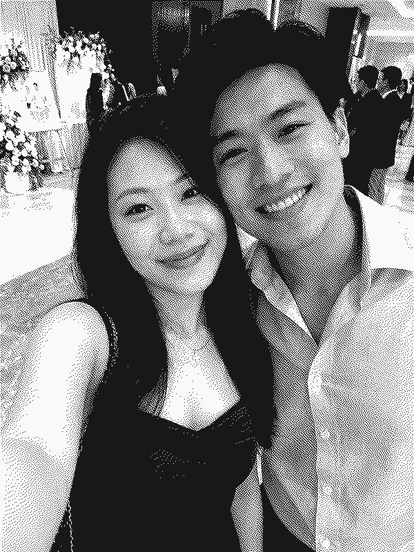 A couple taking a selfie together at a wedding reception, shown as a grainy black-and-white print.
